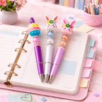 Three decorative pens with rabbit designs on a planner with colorful tabs.