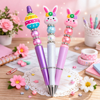 Two decorative pens with rabbit designs on a desk with flowers and stationery.