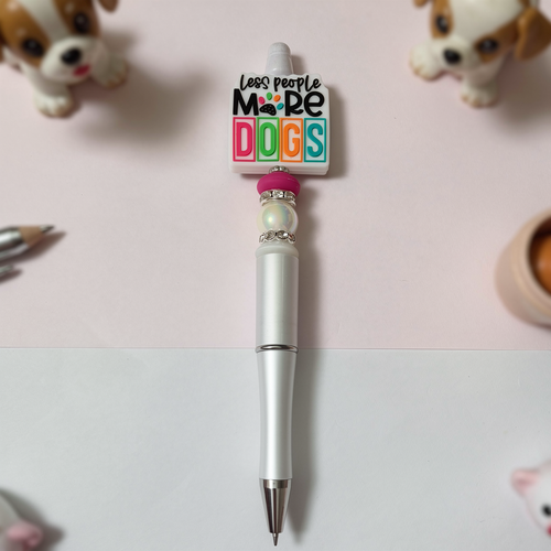 Pen with decorative top featuring 'Less People, More Dogs' text on a light pink background with small dog figurines.