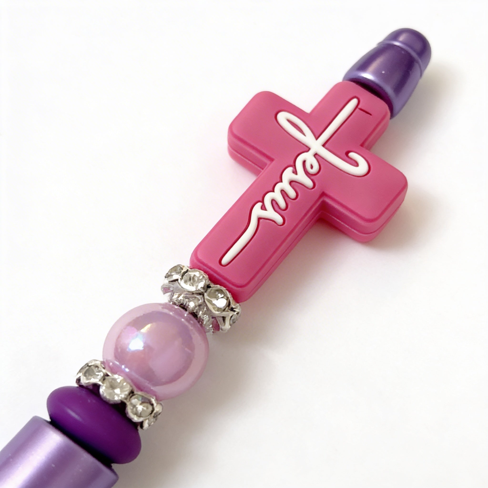 Pink and purple cross-shaped object with 'love' text on a white background