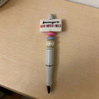 Pen with motivational quote on a wooden surface