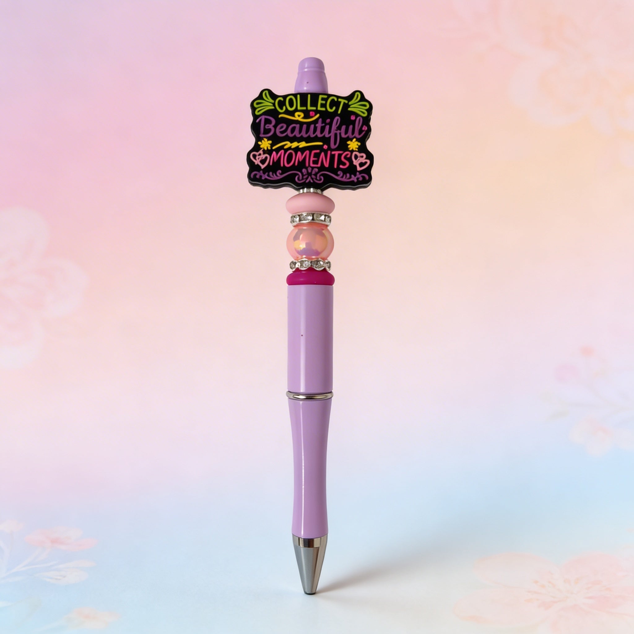Pink pen with decorative top on a pastel gradient background