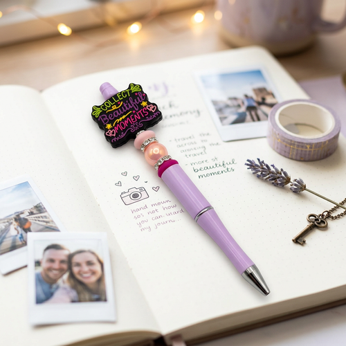 Purple pen with decorative top on an open notebook with photos and tape