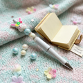 Decorative pen with rabbit charm on a soft fabric background