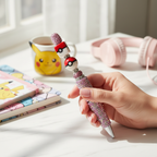 Hand holding crystal rhinestone decorative ballpoint pen while writing at desk